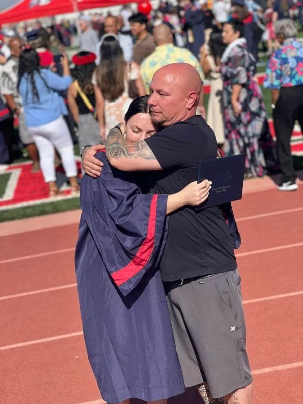 Chris hugging his daughter at her graduation