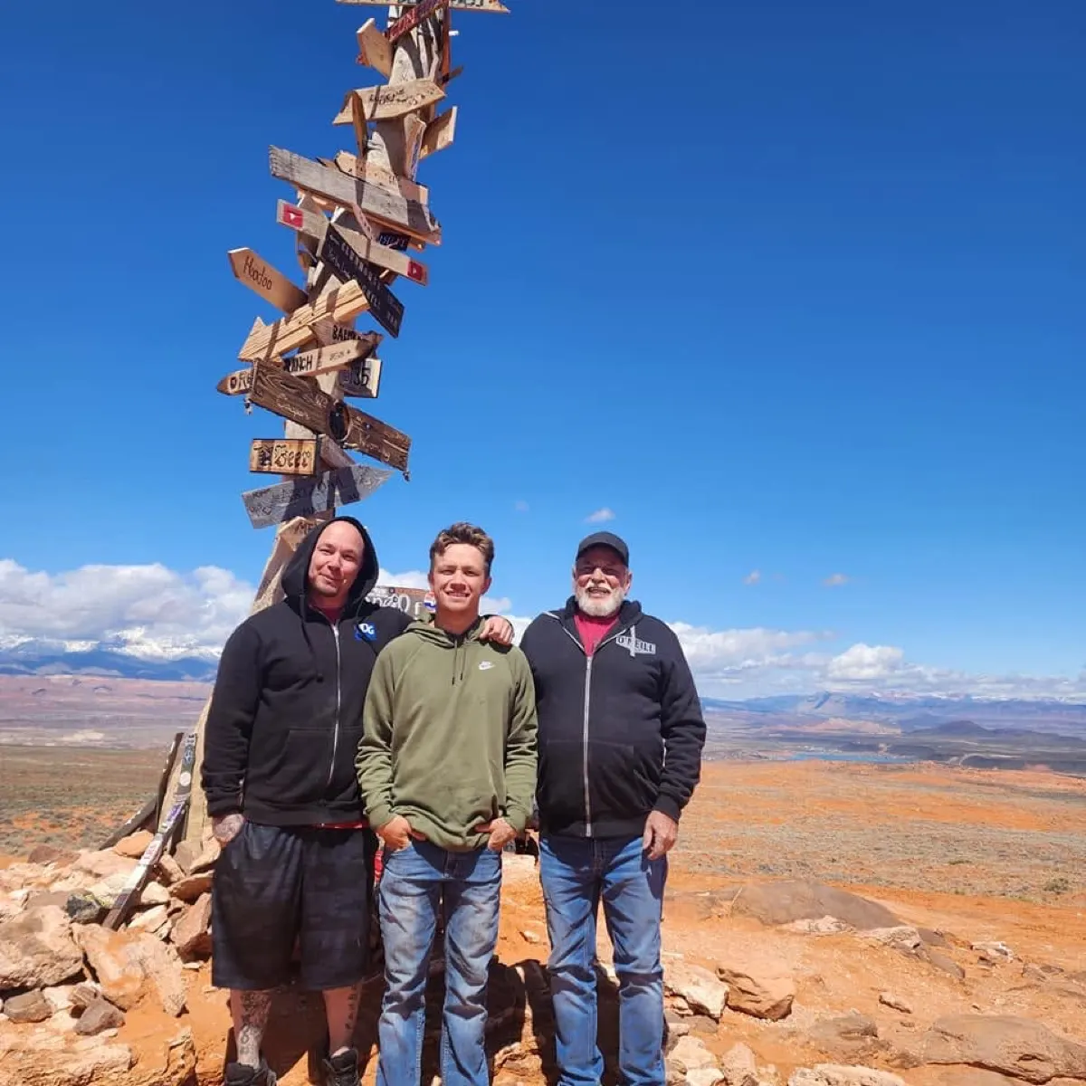 Chris with his son and father on a red rock summit